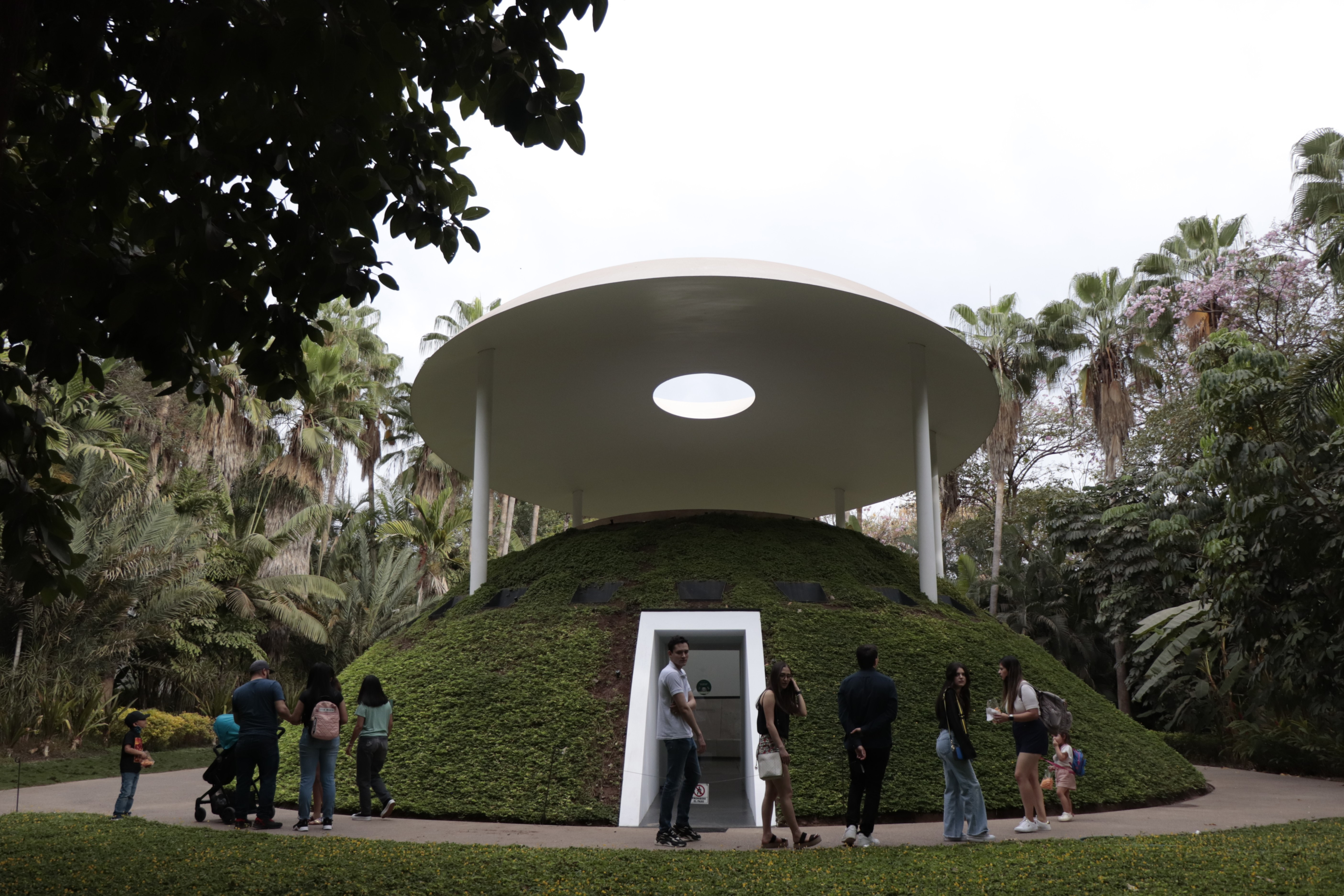 Pabellón Encounter iluminado entre el jardín